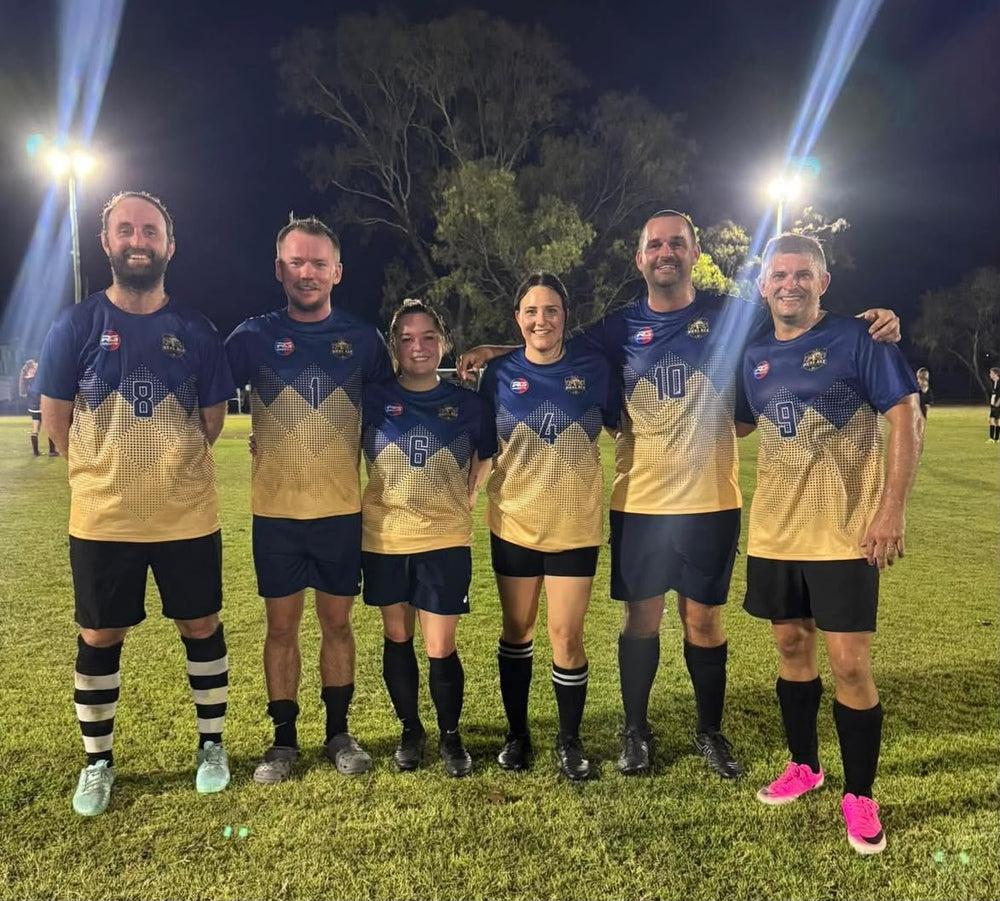 RG Sports team wearing custom navy and gold soccer uniforms on a field