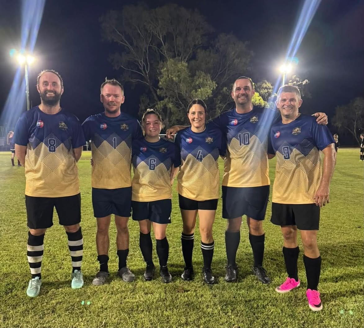 RG Sports team wearing custom navy and gold soccer uniforms on a field