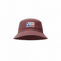 A maroon bucket hat featuring a square embroidered patch on the front with the text 'RG SPORTS' in white, blue, and red, set against a plain white background.